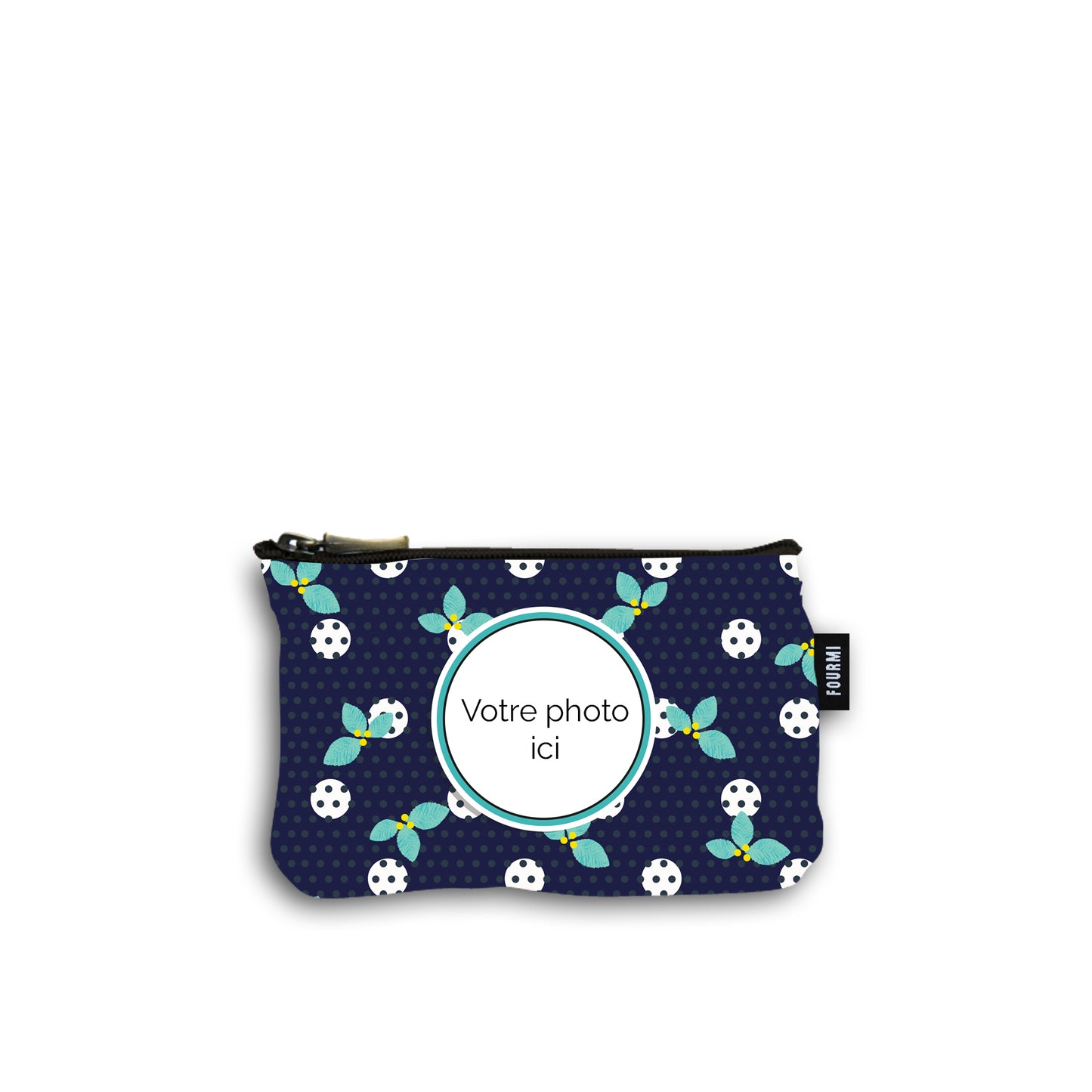 Pochette en coton de 10 centimètres par 15 centimètres . Le fond du motif de la pochette est bleu marine avec des pois noirs et des plus gros pois blanc surmonté de feuilles de houx turquoises avec des petites baies jaunes. On peut imprimer sa photo au centre d'une marie louise turquoise et noire. Pochette avec un zip noir et un curseur couleur bronze.